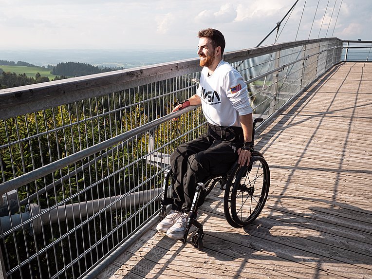 Moritz Brückner im Rollstuhl genießt die Aussicht vom Skywalk Allgäu