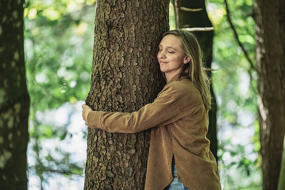 Frau umarmt einen Baum