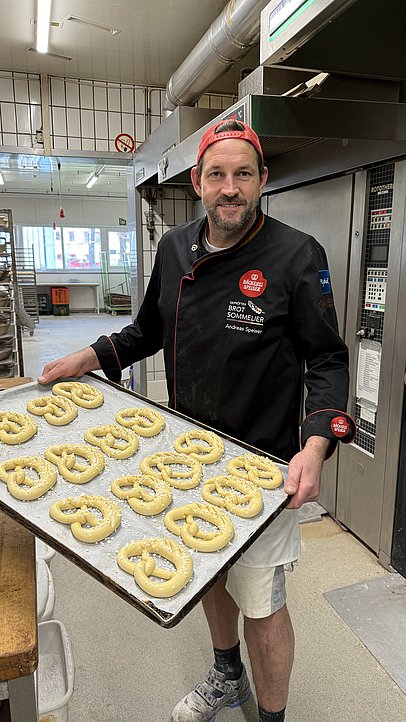 Bäcker Andreas Speiser mit einem Blech Palmbrezen in der Hand