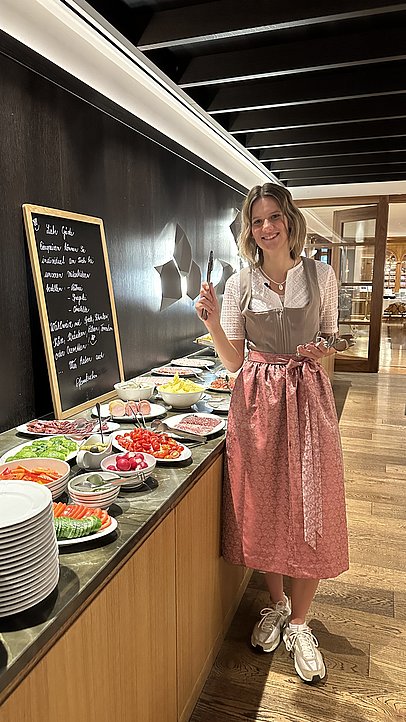 JobQuesterin Pia im Dirndl am Frühstücksbuffet
