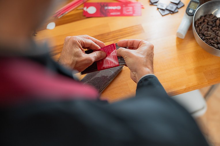 Chocolatier Jonathan Baldinger verpackt eine Schokoladentafel