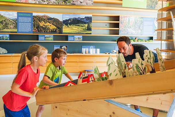 Vater mit zwei Kindern in der Ausstellung im Naturparkzentrum Nagelfluhkette