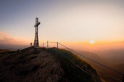 Das Gipfelkreuz auf dem Hochgrat im Licht der untergehenden Sonne