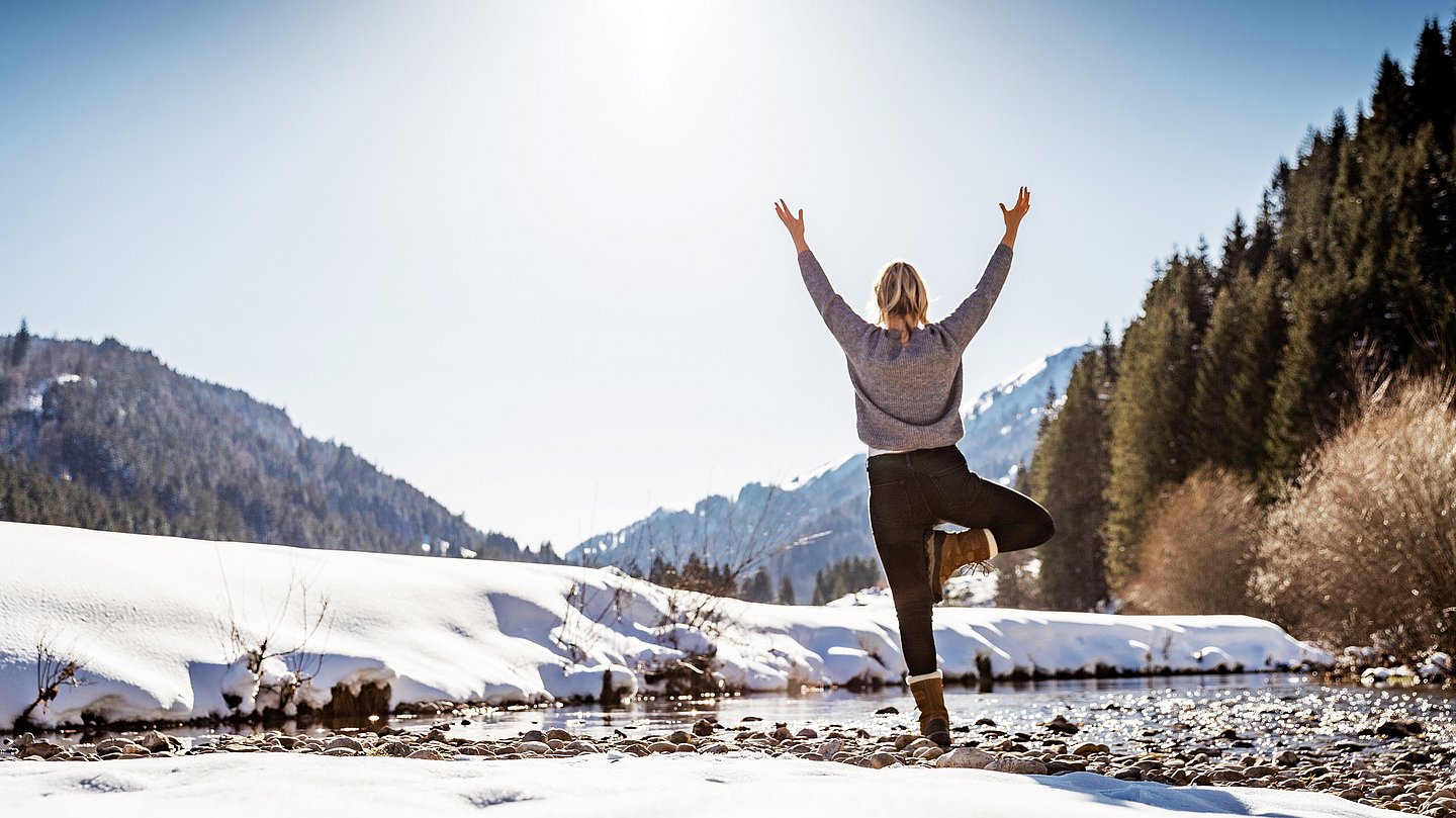 Frau macht Yogaübung in Winterlandschaft