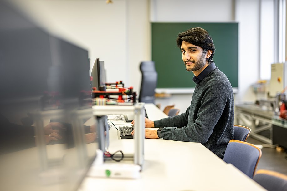 Saqib sitzt an einem Computer