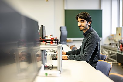 Saqib sitzt an einem Computer