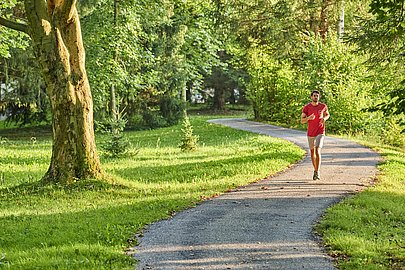 Mann joggt durch den Kurpark von Bad Wörishofen Mann joggt durch den Kurpark von Bad Wörishofen