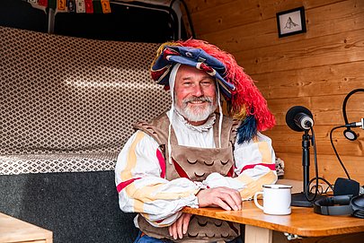 Norbert Sliwockyj in Frundsbergfest-Kleidung im Podcastbus