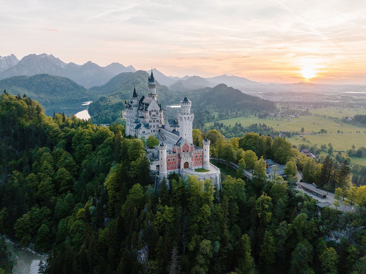 Schloss Neuschwanstein, im Hintergrund Berge, Seen und die untergehende Sonne Schloss Neuschwanstein, im Hintergrund Berge, Seen und die untergehende Sonne