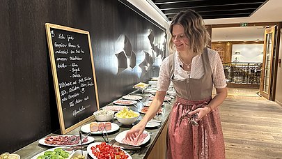 JobQuesterin Pia im Dirndl am Frühstücksbuffet