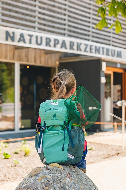 Kinde mit Forscherrucksack vor dem Naturparkzentrum Nagelfluhkette