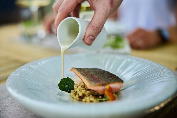 Teller mit Fischfilet auf Linsen mit Kapuzinerkresse