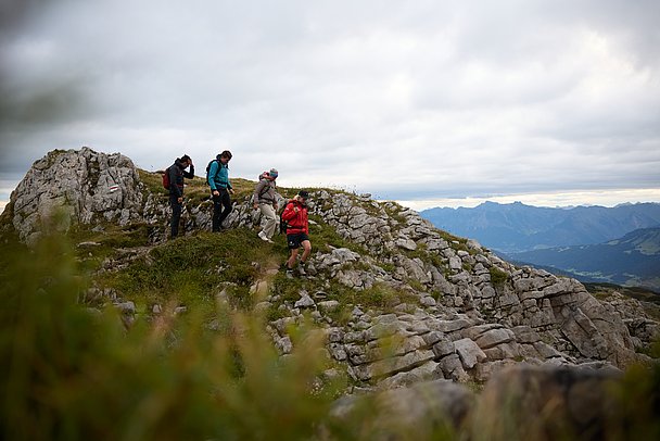 Wandergruppe in einer Landschaft aus Fels und Gras