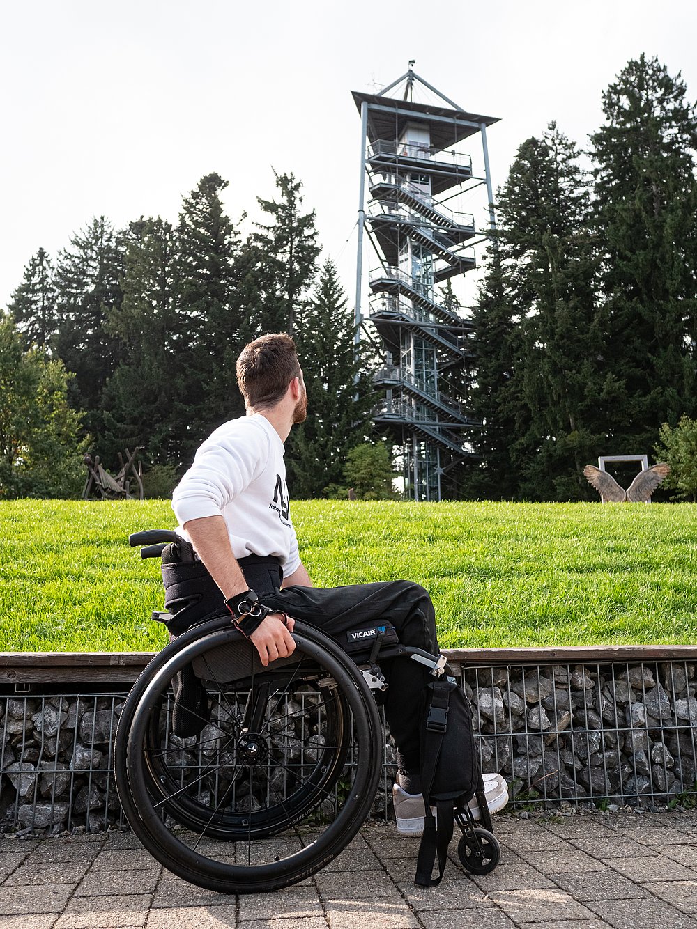 Moritz Brückner im Rollstuhl vor dem Turm der Waldwelt Skywalk Allgäu