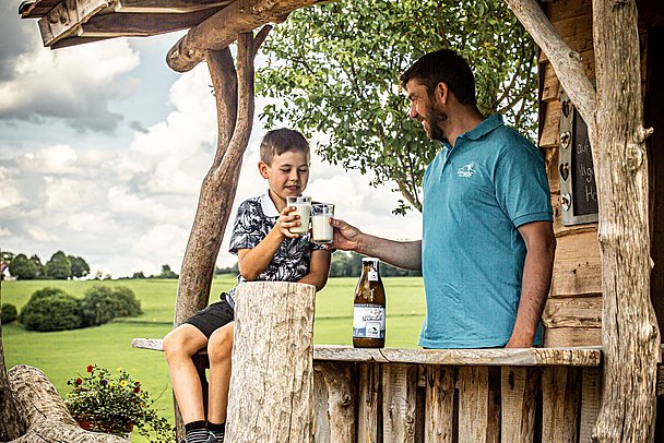 Vater und Sohn genießen eine Milch aus dem Milchautomaten