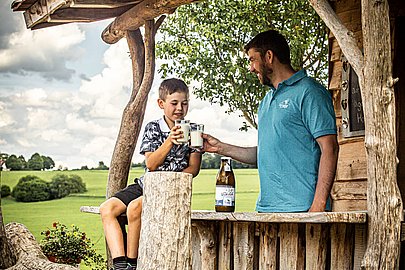 Vater und Sohn genießen eine Milch aus dem Milchautomaten