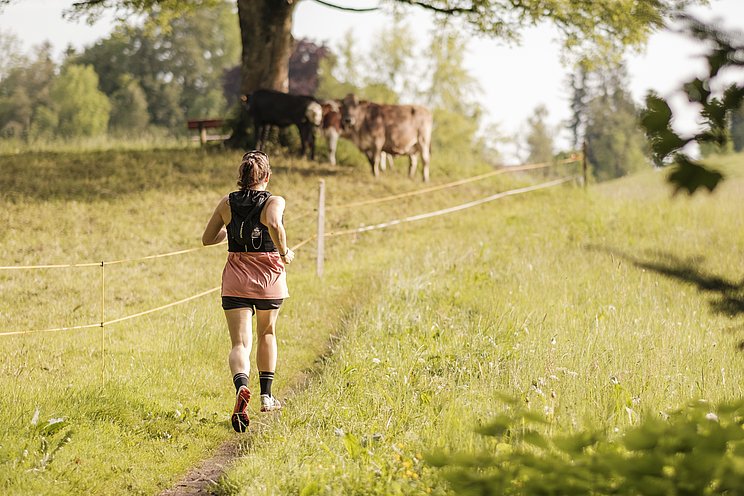 Sarina Berchtold von hinten beim Laufen über eine Wiese
