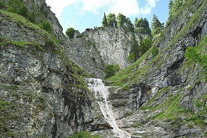 Wasserfall fließt über eine hohe Felswand