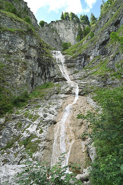 Wasserfall fließt über eine hohe Felswand