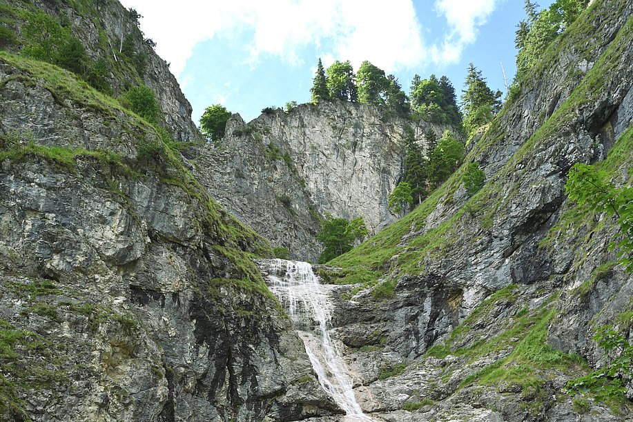 Wasserfall fließt über eine hohe Felswand