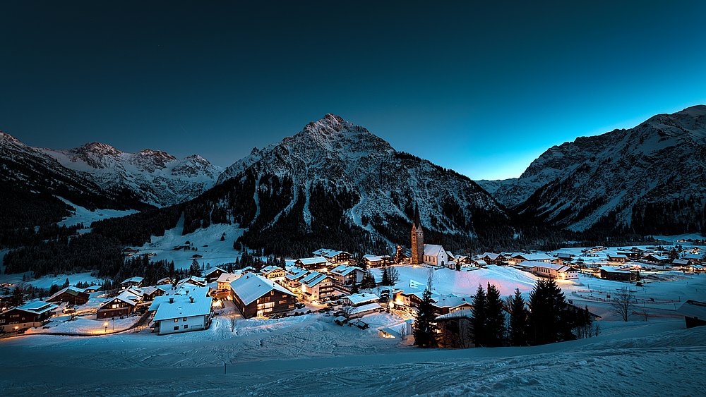 Verschneites Mittelberg und Berge bei Nacht