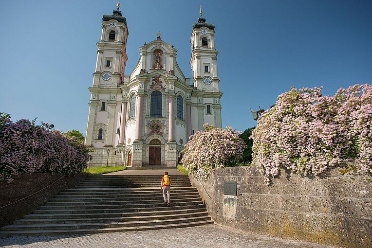Frau steigt die Stufen zur Basilika Ottobeuren hinauf Frau steigt die Stufen zur Basilika Ottobeuren hinauf