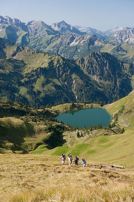 Wandergruppe beim Aufstieg über dem Seealpsee, im Hintergrund die Allgäuer Alpen