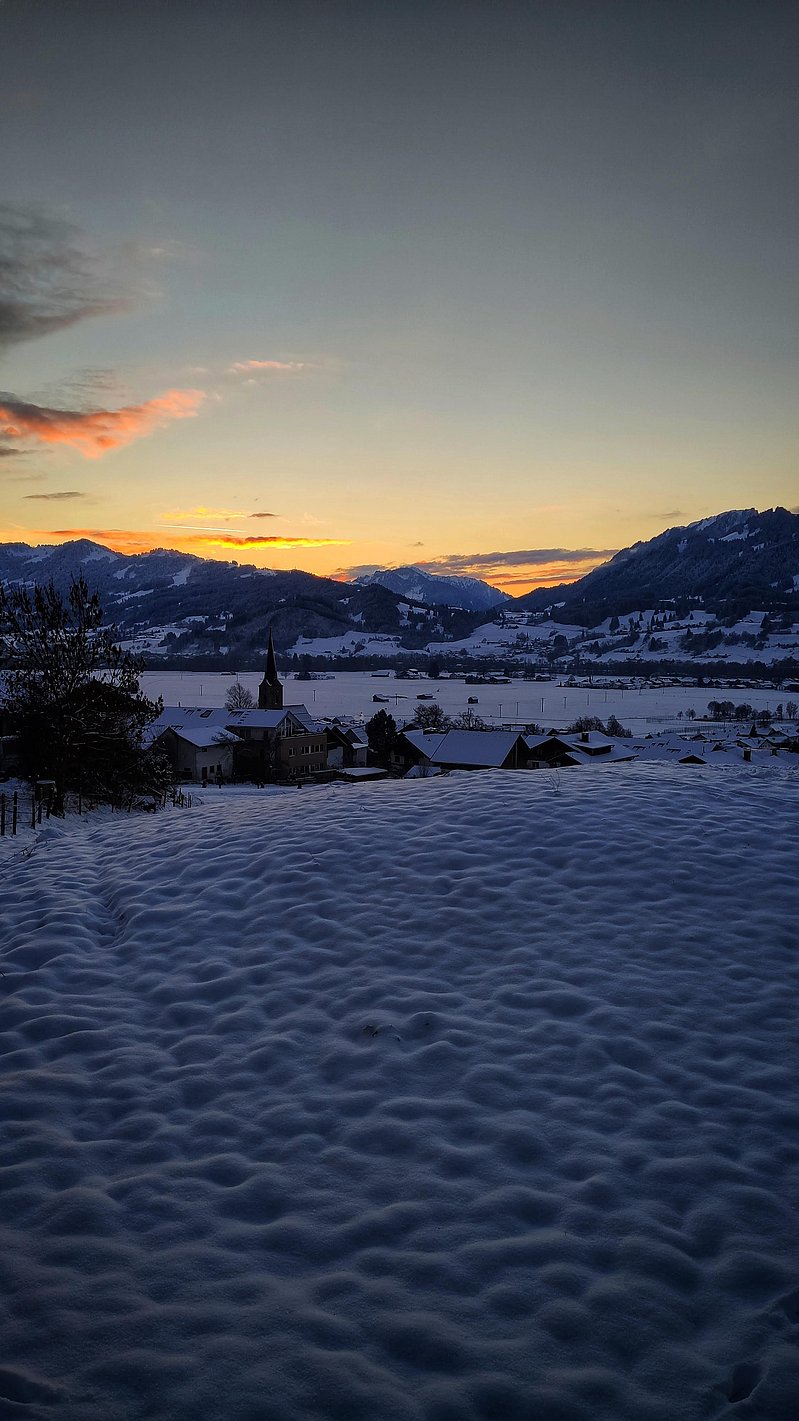 Allgäuer Winterlandschaft bei Dämmerung. Blick auf das Alpenpanorama