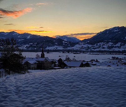 Allgäuer Winterlandschaft bei Dämmerung. Blick auf das Alpenpanorama