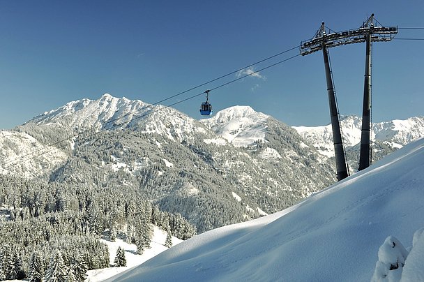 Gondel der Hornbahn vor verschneiten Bergen