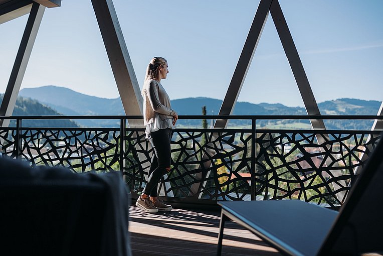 Frau auf einer Terrasse der Rosenalp mit Blick in die Berge Frau auf einer Terrasse der Rosenalp mit Blick in die Berge