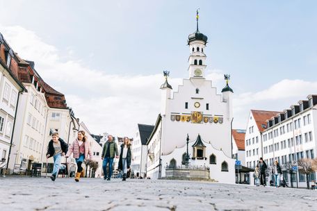 Familie schlendert über den winterlichen Rathausplatz.