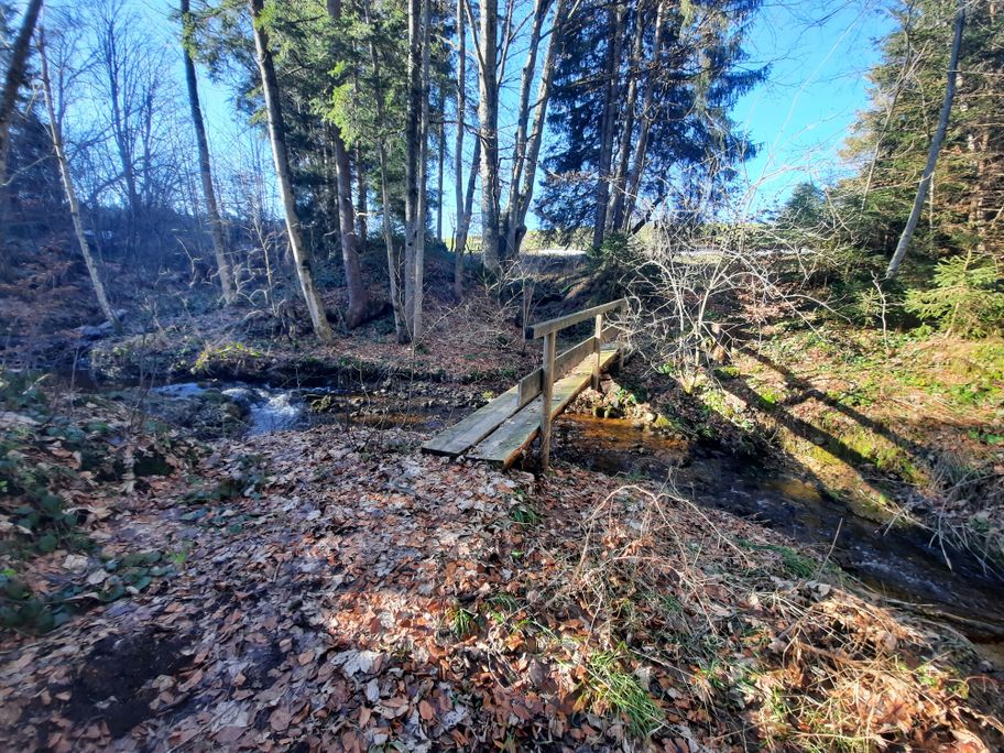 Romantischer Bachlauf mit Brücke unterhalt Rechtis