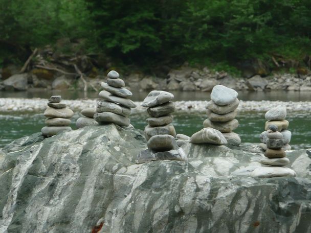 Kleine Kunstwerke in Form von Steinmännchen an der Iller bei Fischen im Allgäu