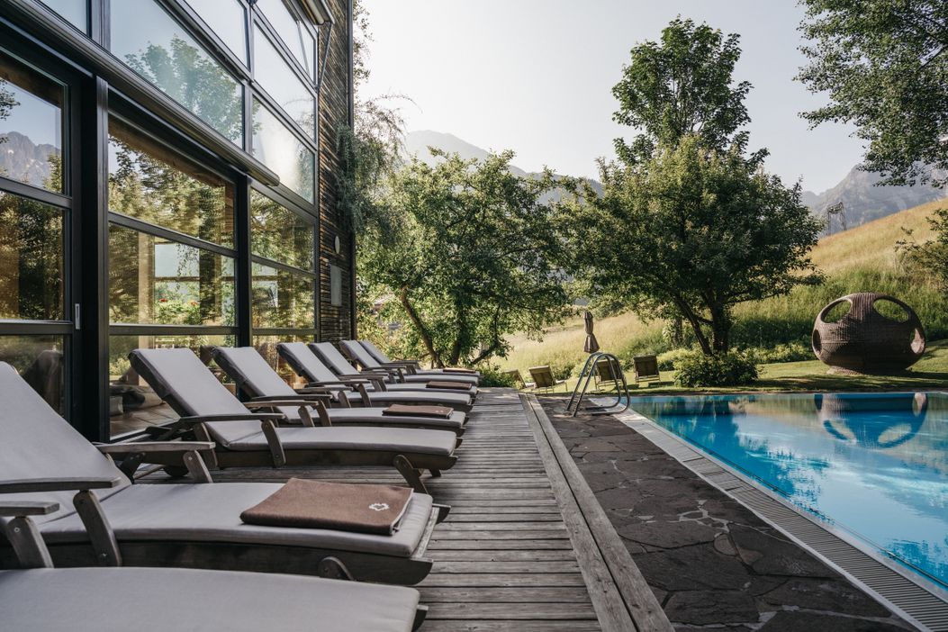 naturhotel_chesa_spa_outdoorpool_sommer_liegen__hotel_blick_berge