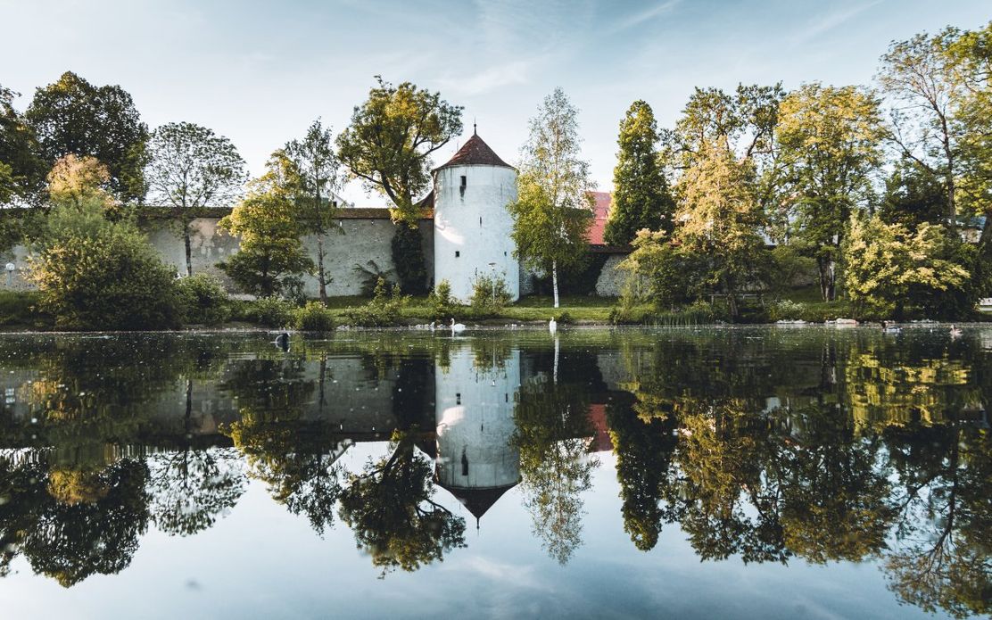 der_wehrgang_mit_dem_speicherturm_spiegelt_sich_um_wasser_des_kurpark-weihers
