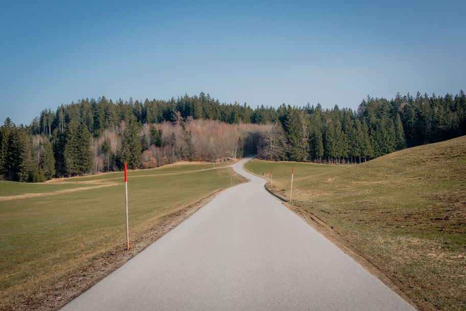 Geteerte Nebenstraße schlängelt sich bergaufwärts von Schweinegg Richtung Zell.