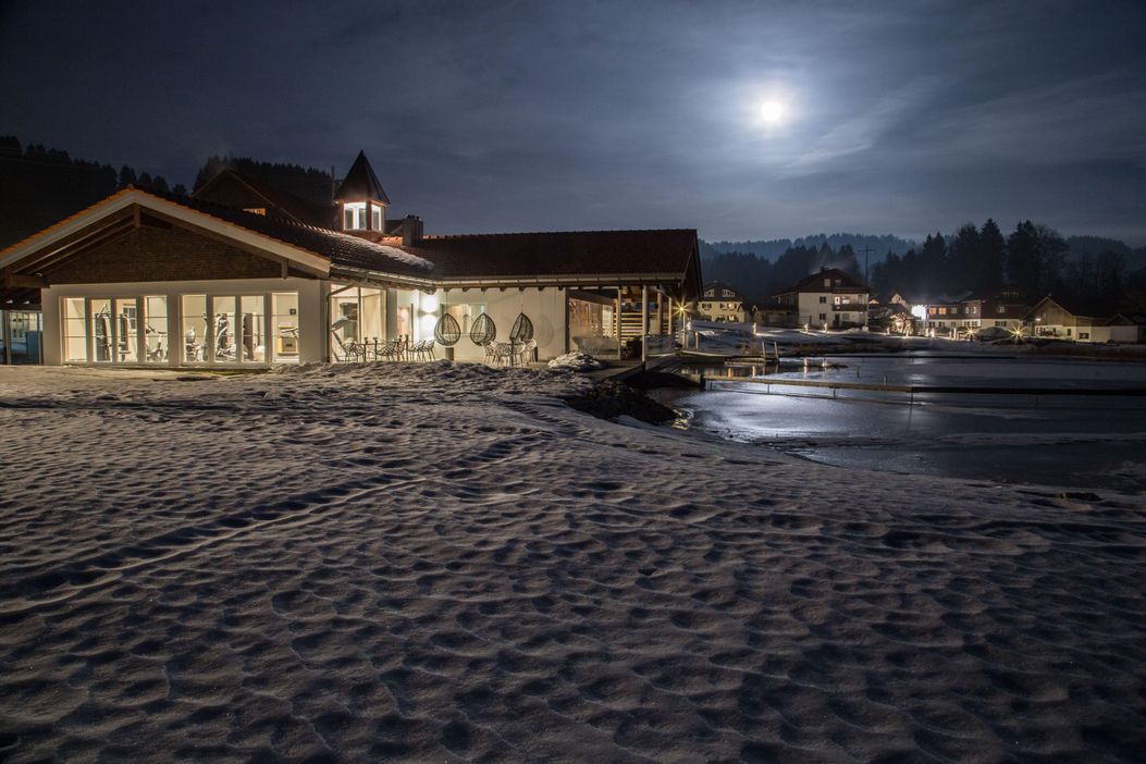 Haus am See im Winter bei Nacht