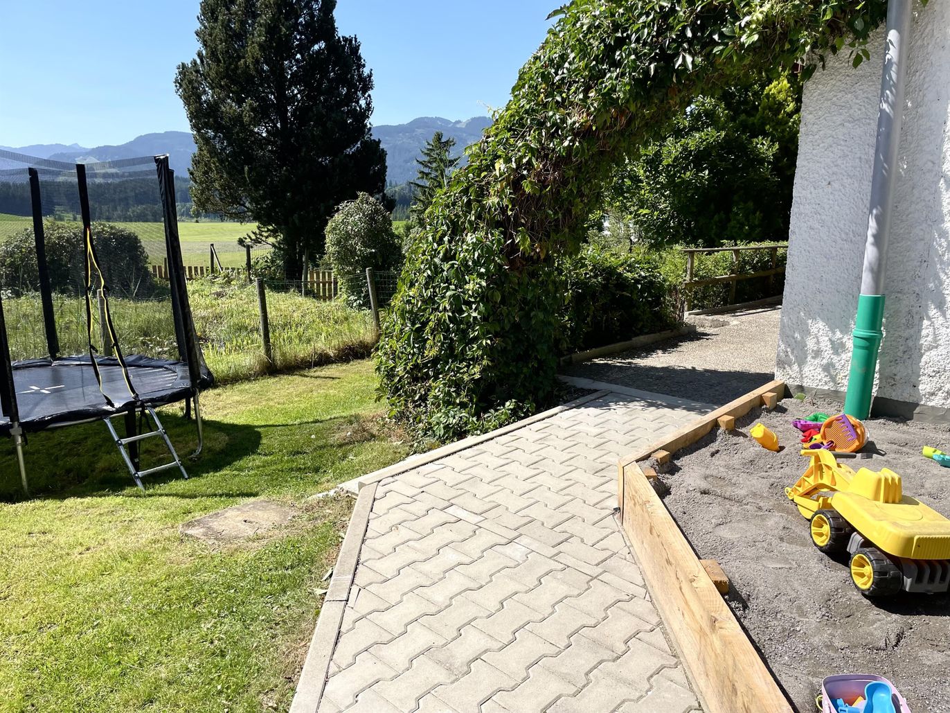 Eingangsbereich mit Trampolin und Sandkasten