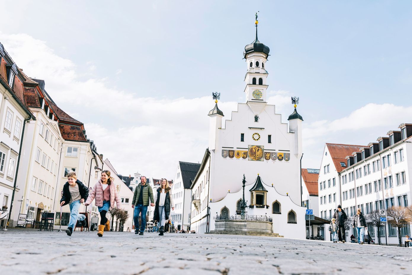 Familie schlendert über den winterlichen Rathausplatz.