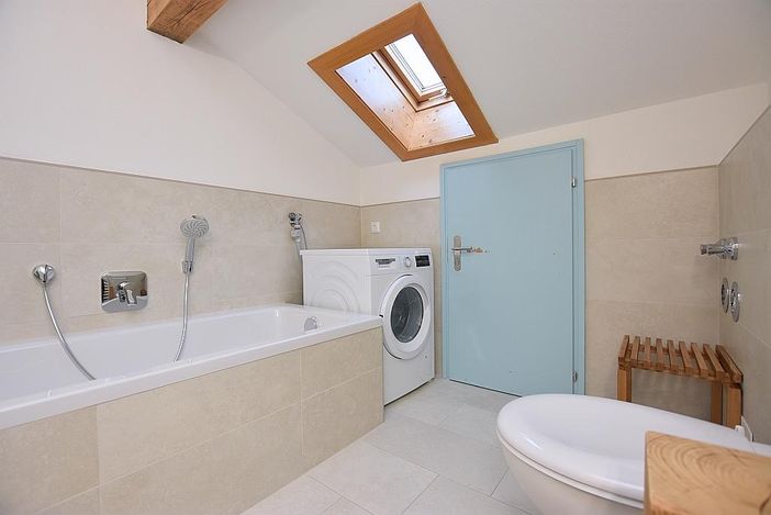 Bathroom with bathtube, shower, washing machine