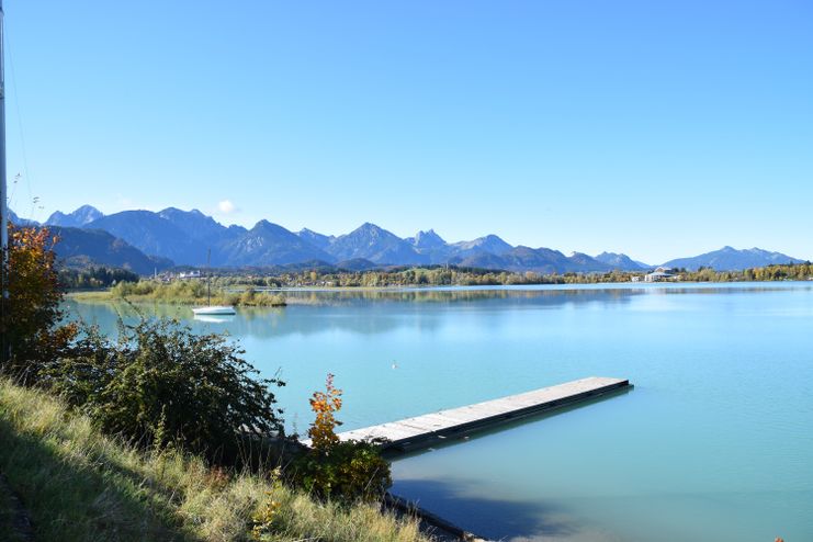 Forggensee mit Steg und Berge im Hintergrund