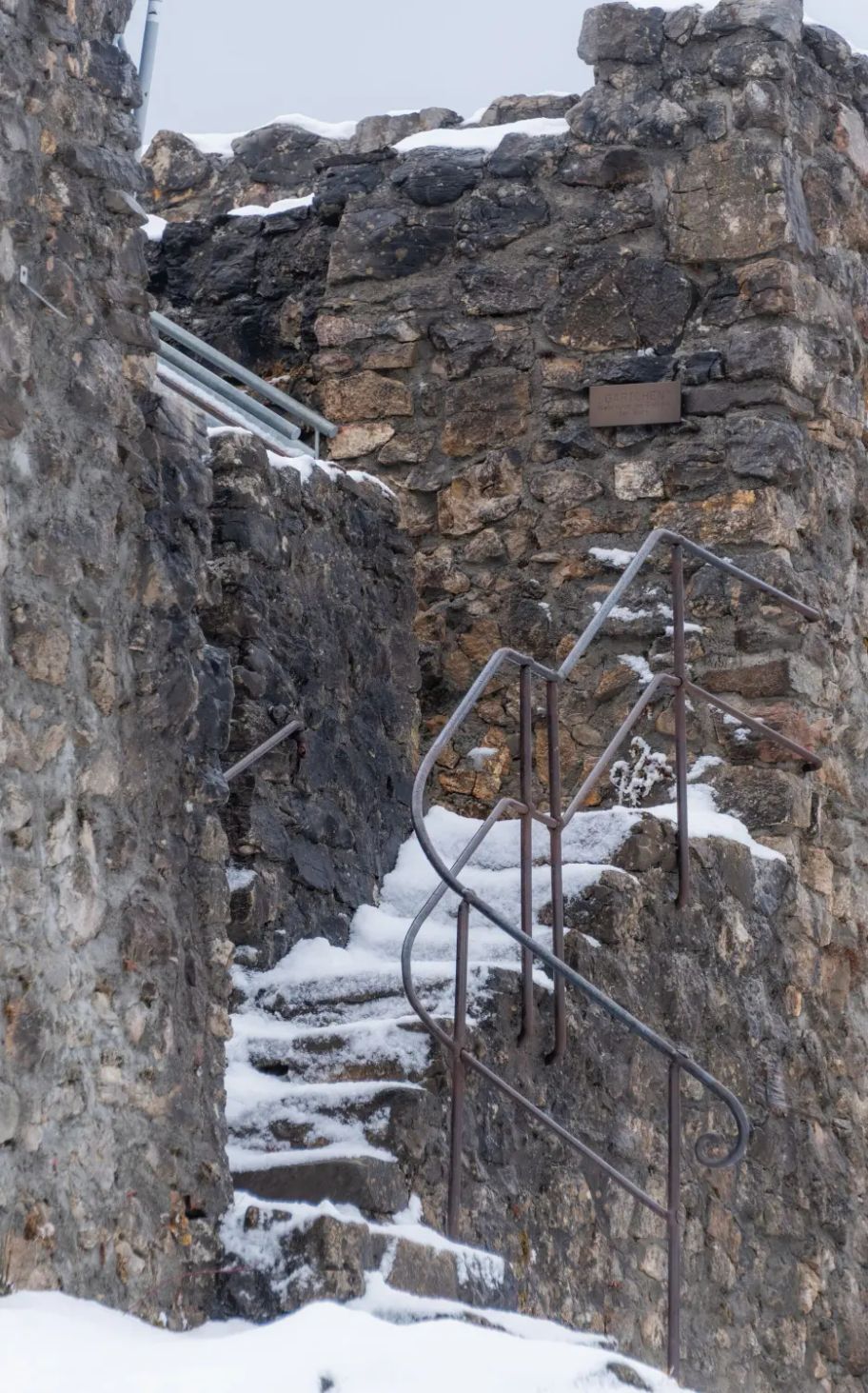 Eine mit schneebedeckte und vereiste Steintreppe führ zu einem Aussichtplateau.
