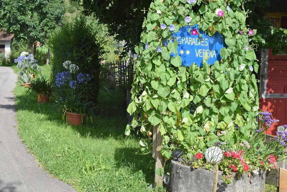 Hausschild mit viel Blumen