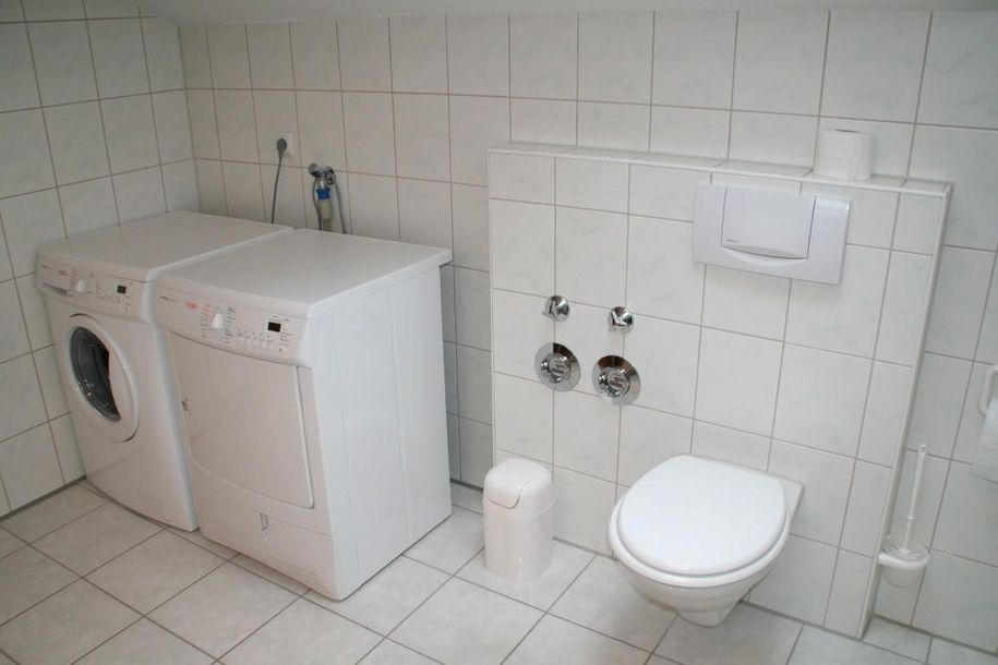 Badezimmer mit WC, Waschmaschine und Wäschetrockne