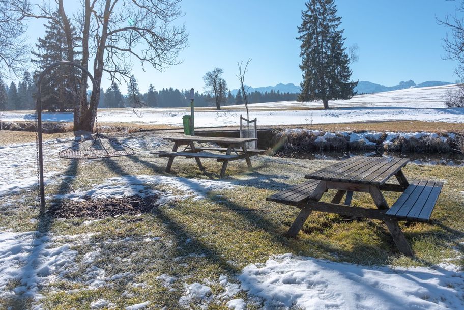Über eine kleine Holzbrücke gelangt man zu Sitzmöglichkeiten am Grillplatz entlang des Ufers der Lobach.