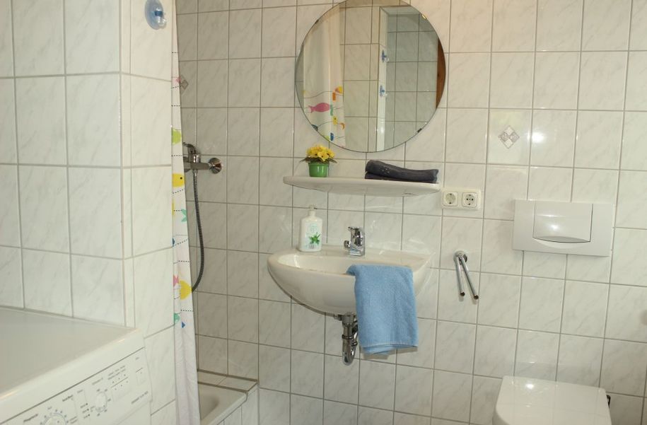 helles Badezimmer mit Waschmaschine