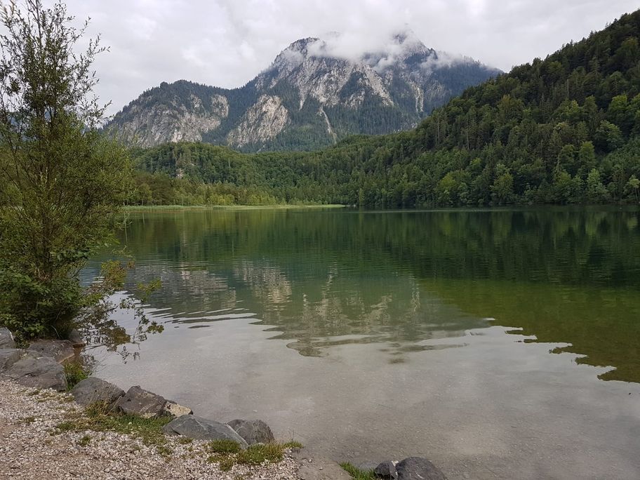 Schwansee mit wolkenverhangenem Säuling im Hintergrund