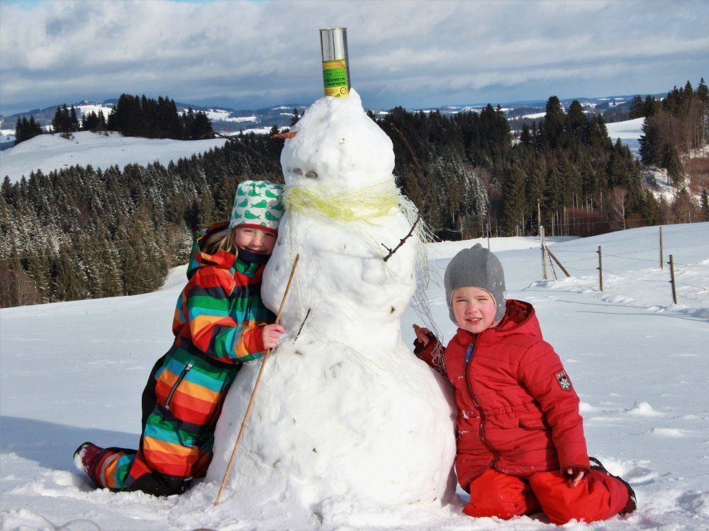 Winterfreuden: Kinder bauen Schneemann