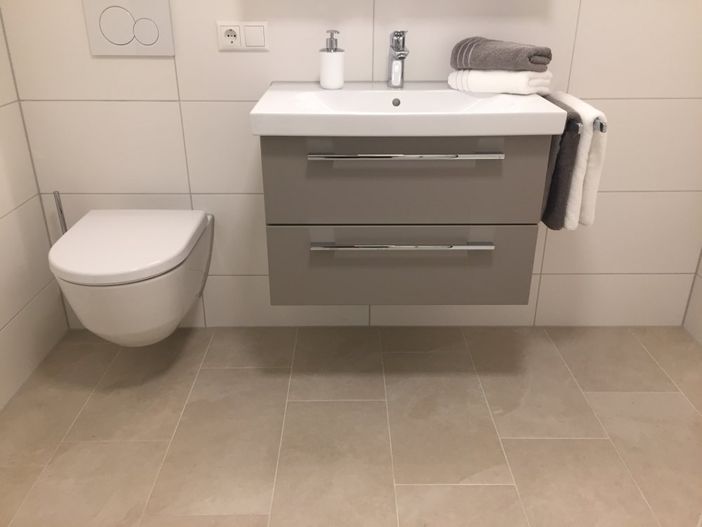Neues Bad mit Waschtisch, Spiegelschrank Dusche und Waschmaschine.